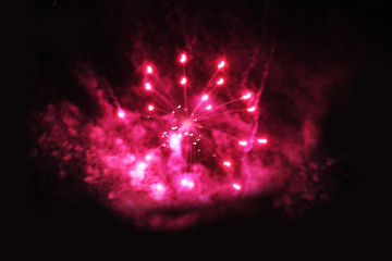 Fireworks. Salute. Fantasy of bright pink and colorful lights in the night sky during the holiday of New Year and Christmas