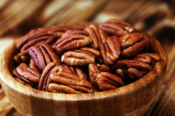Pecan nuts on a table and pecan nuts in bowl