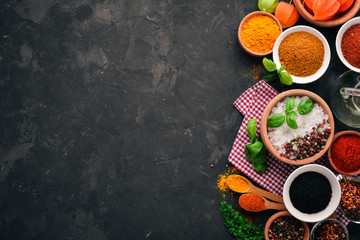 A set of spices and herbs on a stone table. Indian traditional spices. Top view. Free copy space.