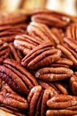 Pecan nuts on a table and pecan nuts in bowl