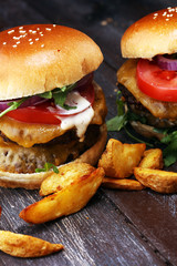 Tasty fresh meat burgers with salad and cheese and potato wedges. Homemade angus burger.