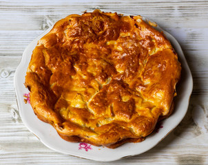 apple pie on a plate. Wooden table. close up.