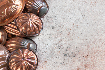 Vintage copper molds on a concrete background.