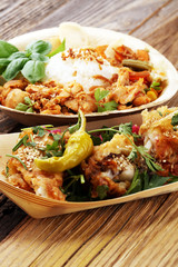 various street food with chicken wings on rustic background. balinese nasi campur and indian and brasilian street food.