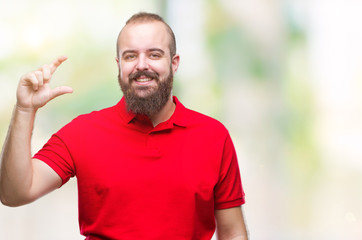 Young caucasian hipster man wearing red shirt over isolated background smiling and confident gesturing with hand doing size sign with fingers while looking and the camera. Measure concept.