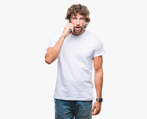 Handsome hispanic man model talking on smartphone over isolated background scared in shock with a surprise face, afraid and excited with fear expression