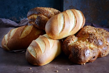 Delicious freshly baked bread on wooden background. Bakery product assortment with bread loaves,...
