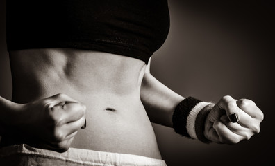Beautiful and strong woman's abs with metre. Image in black and white style