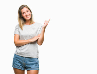 Young beautiful woman over isolated background with a big smile on face, pointing with hand and finger to the side looking at the camera.