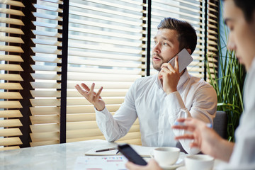 Businessman speaking on phone having meeting