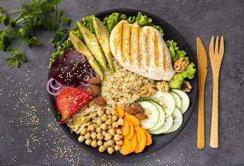 Bowl of Buddha, The concept of a healthy diet: grilled chicken, avocado, chickpeas, kinua, carrots, tomatoes, nuts. Balanced food. Top view. Copy space.