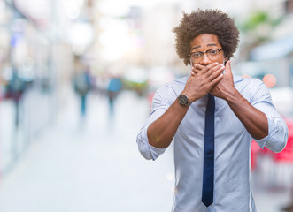 Afro american business man wearing glasses over isolated background shocked covering mouth with hands for mistake. Secret concept.