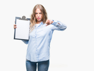 Beautiful young blonde business woman holding clipboard over isolated background with angry face,...