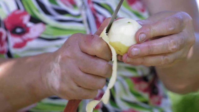 Close-Up of Old Woman's Hand with a Knife Crop Apple Peel