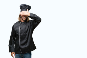 Young handsome cook man with long hair over isolated background smiling and laughing with hand on face covering eyes for surprise. Blind concept.