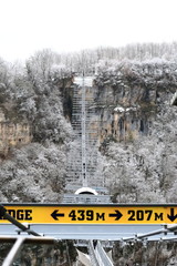 High-mountain, suspended rope bridge, which offers stunning views of the gorge, which runs a mountain river and a view of the village located far away in the valley