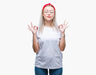 Obraz na płótnie Canvas Young blonde woman wearing glasses over isolated background relax and smiling with eyes closed doing meditation gesture with fingers. Yoga concept.