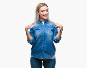 Young blonde woman over isolated background looking confident with smile on face, pointing oneself with fingers proud and happy.