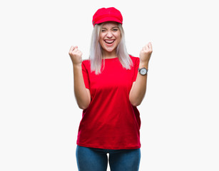 Fototapeta na wymiar Young blonde woman wearing red hat over isolated background celebrating surprised and amazed for success with arms raised and open eyes. Winner concept.