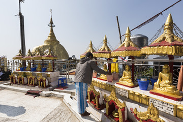 Hombre haciendo ofrendas en el templo budista de Kyaiktiyo Pagoda en Myanmar.