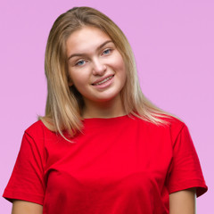 Fototapeta premium Young caucasian woman over isolated background looking away to side with smile on face, natural expression. Laughing confident.