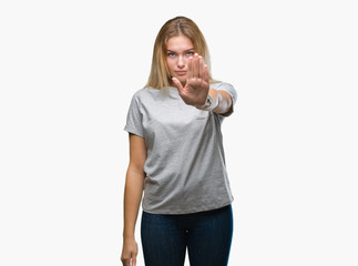 Young caucasian woman over isolated background doing stop sing with palm of the hand. Warning...