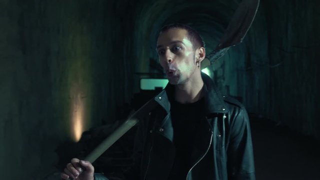 portarit of Crazy maniac psychopathic singing and striking with a shovel.Psicopathy,violence