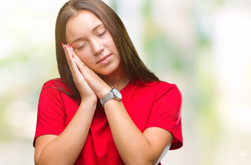 Young beautiful caucasian woman over isolated background sleeping tired dreaming and posing with hands together while smiling with closed eyes.