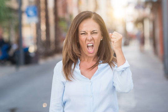 Beautiful Middle Age Hispanic Woman At The City Street On A Sunny Day Annoyed And Frustrated Shouting With Anger, Crazy And Yelling With Raised Hand, Anger Concept