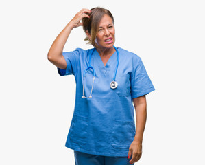 Middle age senior nurse doctor woman over isolated background confuse and wonder about question. Uncertain with doubt, thinking with hand on head. Pensive concept.