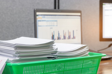 Stack of student's homework assignment books in basket on teacher's table waiting to be managed and...