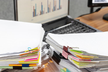 Close up pile of unfinished paperwork on teacher's desk in office waiting to be managed and...