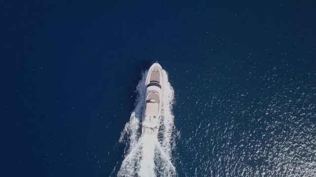 Medium sized Yacht roaring across The Mediterranean Sea - Top down aerial footage following the Yacht.