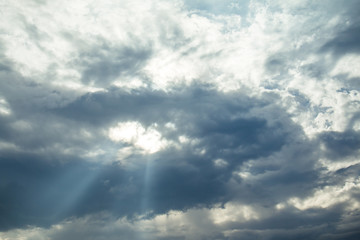 Fototapeta na wymiar light rays on dramatic moody blue sky