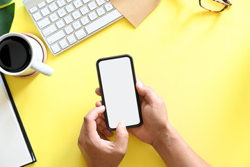 Businessman holding blank screen mobile smart phone on desk work.