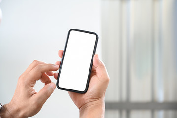 Cropped shot male hand using mobile phone.