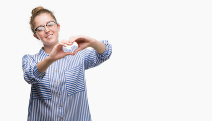 Young blonde business woman smiling in love showing heart symbol and shape with hands. Romantic concept.