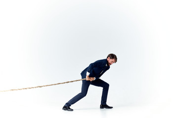 man pulls the rope on a light background