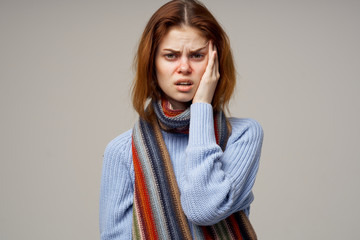 woman with a scarf holds her hand on her head