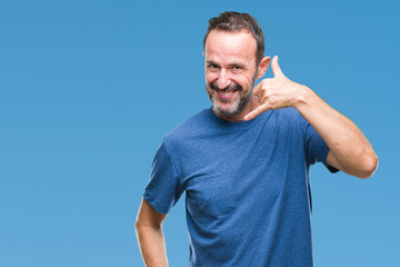 Naklejka premium Middle age hoary senior man over isolated background smiling doing phone gesture with hand and fingers like talking on the telephone. Communicating concepts.