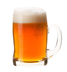 Cold mug of orange beer with foam isolated on white background.
