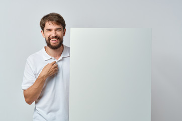 joyful man stands holding white mockup