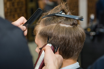 Fototapeta premium To shave hair to make a haircut for a man with a typewriter