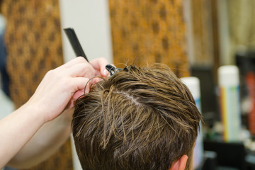 Fototapeta premium Scissor the hair of a man in a barbershop