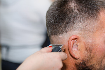 To shave hair to make a haircut for a man with a typewriter