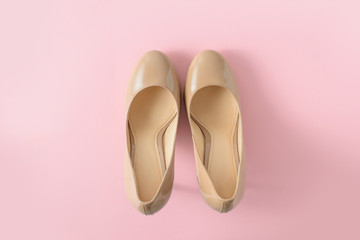 Fototapeta premium Beige women high heel shoes on pink background. Fashion blog look. Top view, flat lay.