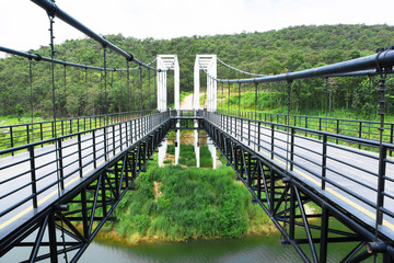 Metal suspension bridge at Mae kuang Udom Thara dam background in Chiang mai,Thailand