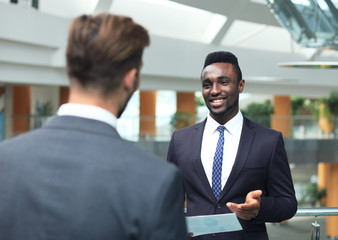 Fototapeta premium Two multinational young businessmen discussing business at meeting in office.