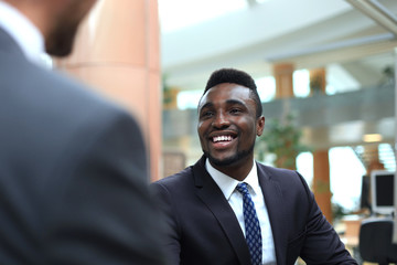 Business meeting. African American businessman shaking hands with caucasian businessman.