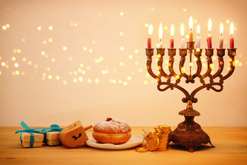 image of jewish holiday Hanukkah background with traditional spinnig top, menorah (traditional candelabra) and burning candles.